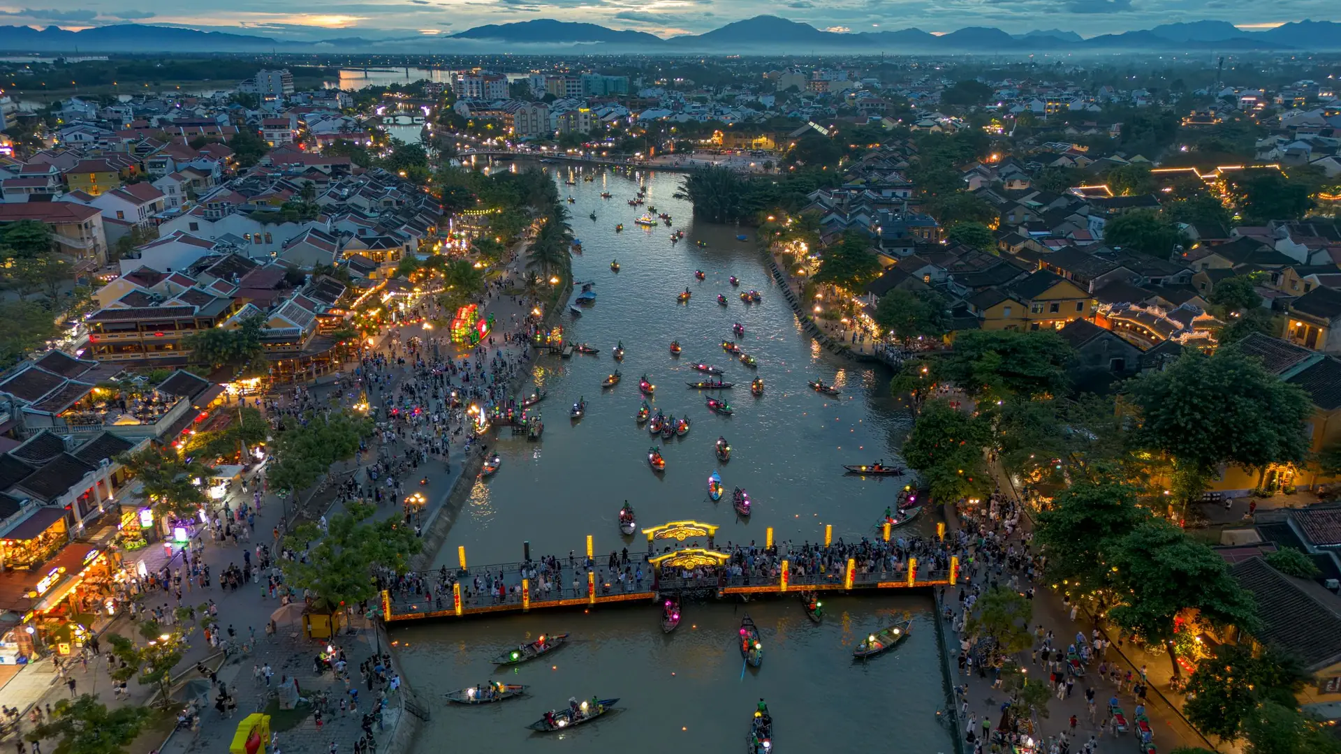 Aerial view of Hoi An old town at night, with lantern boats on the river
