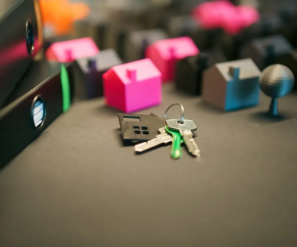 House keys on a desk next to small model houses
