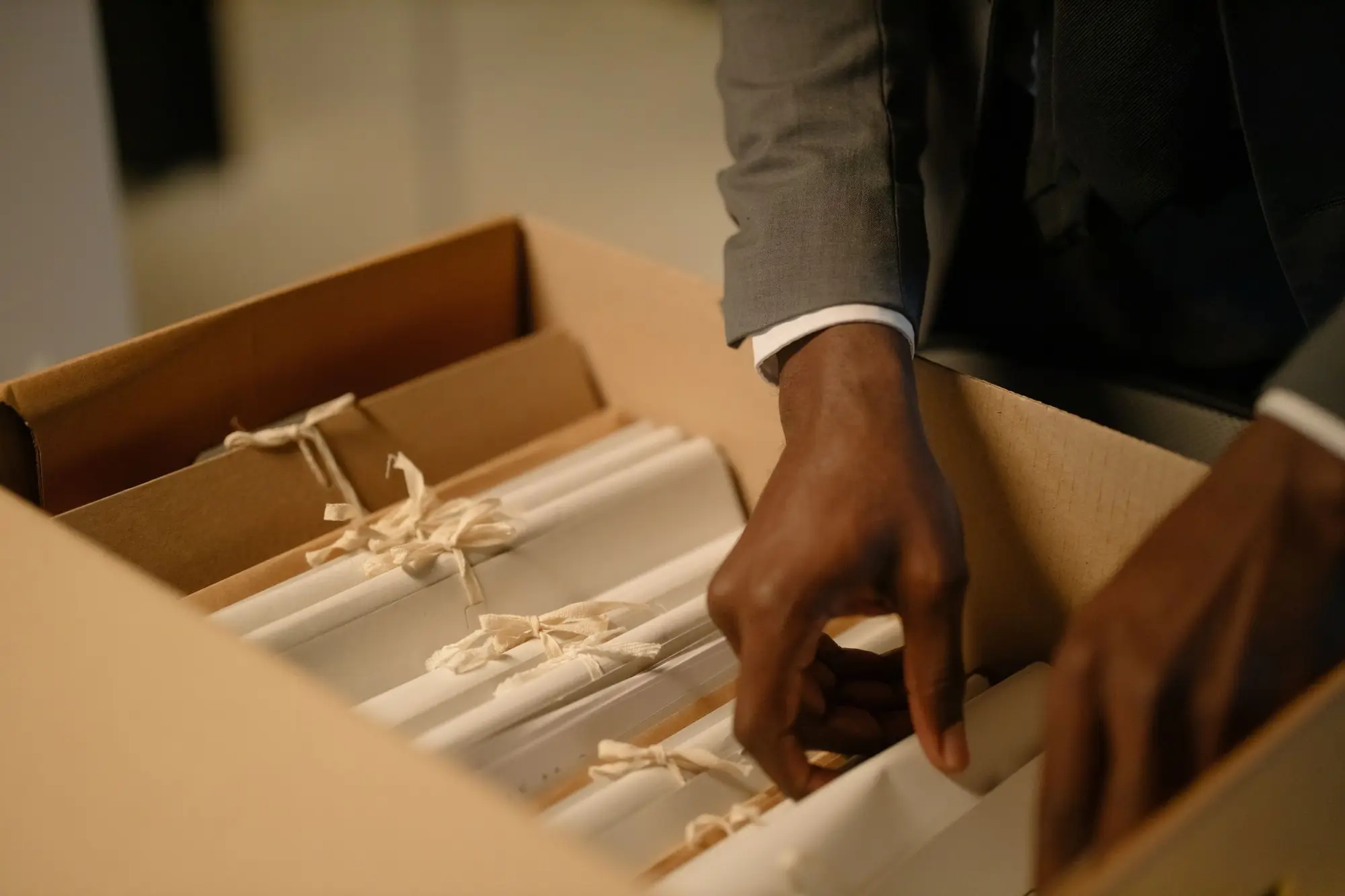 Hands sorting through tied bundles in a file box
