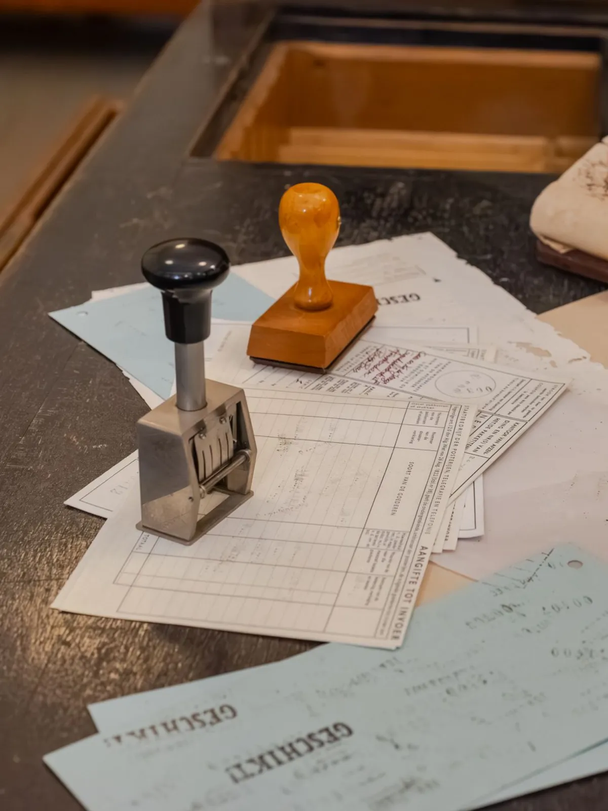 A rubber stamp and a date stamp on printed forms on a desk