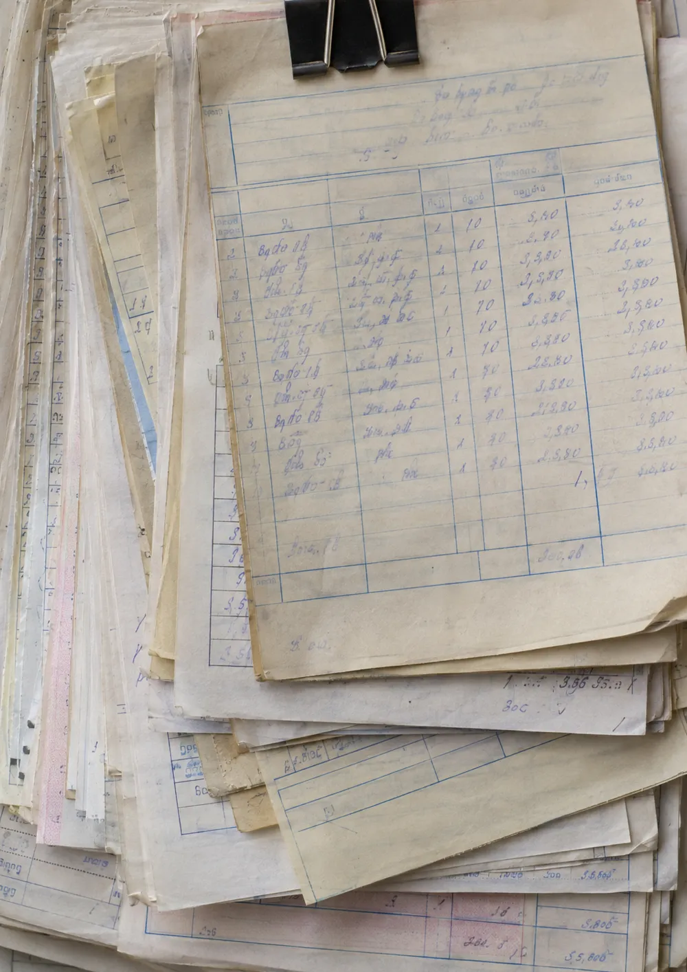 Generated image: a bundle of paper purchase invoices held by a clip