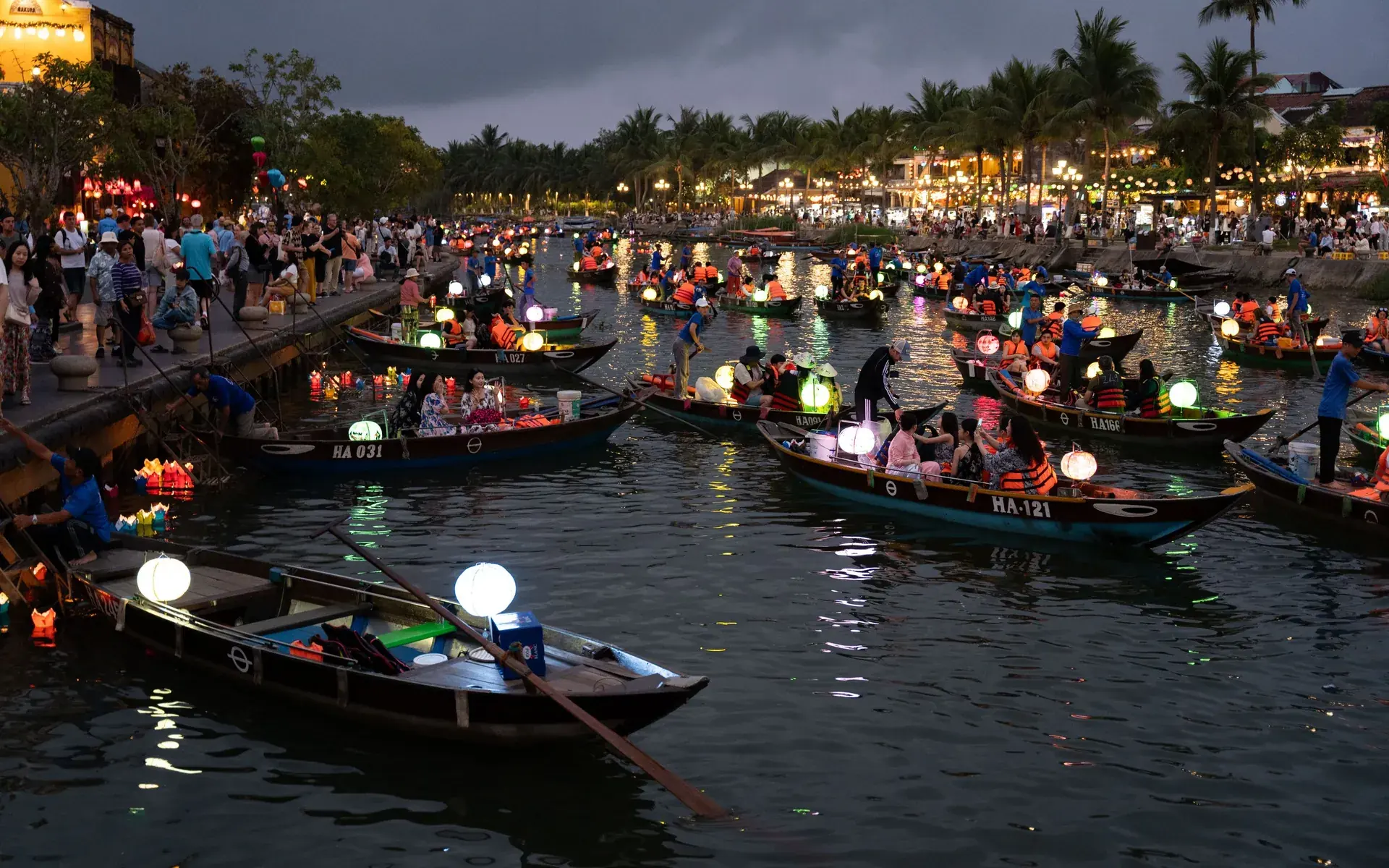 Boats with glowing lanterns on the river in Hoi An at night