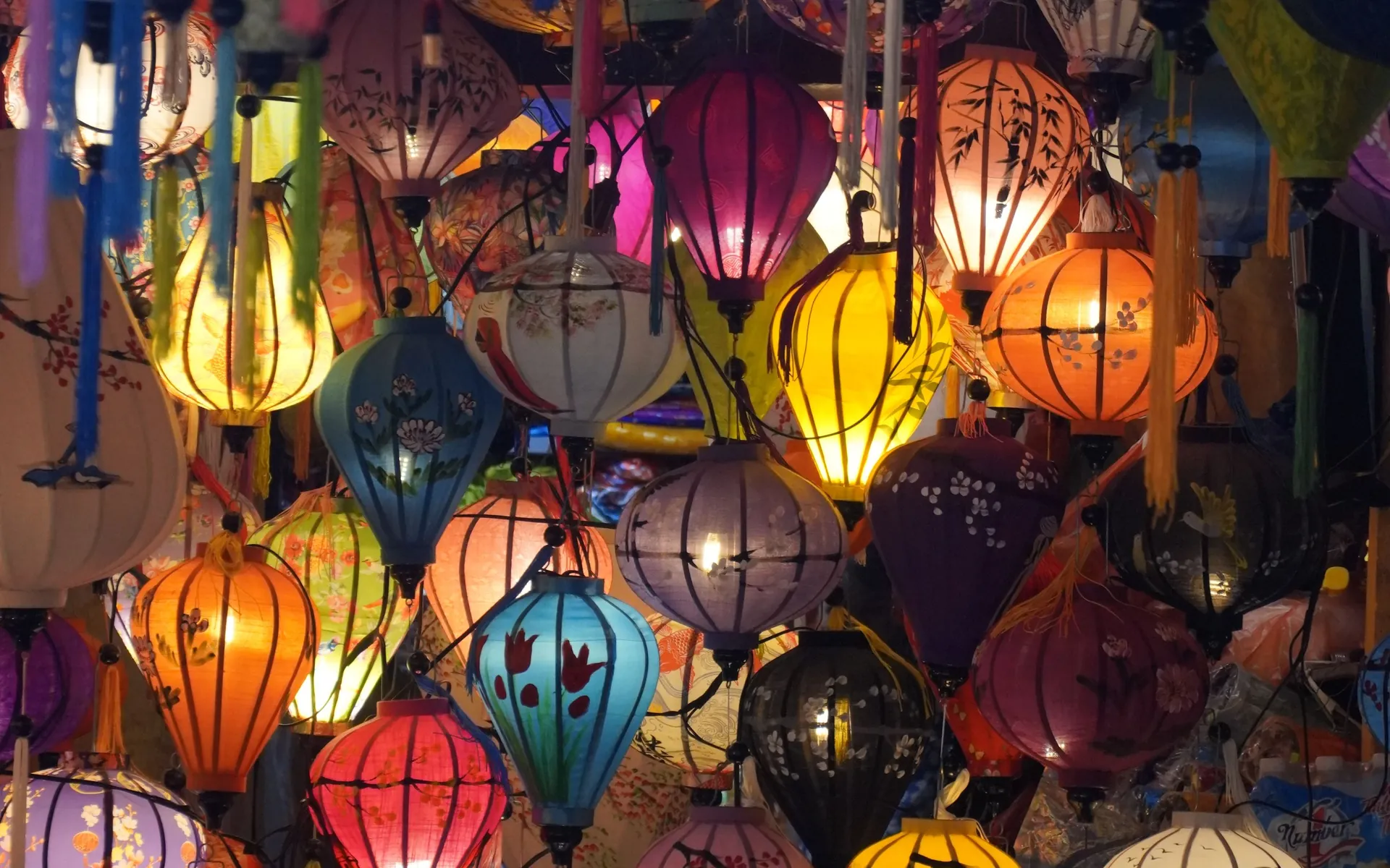 A lantern shop in Hoi An at dusk, its silk lanterns lit